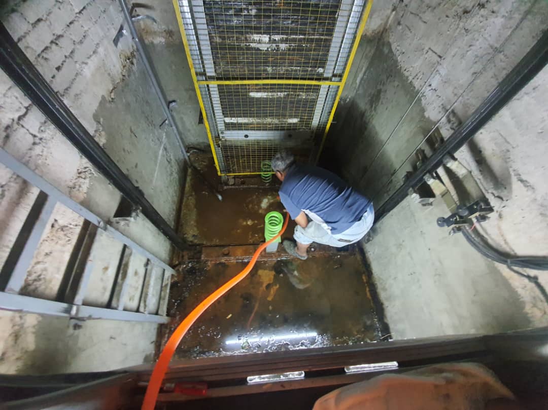 A Rope Access Safety Technician at protruding building facade, scaling upwards.