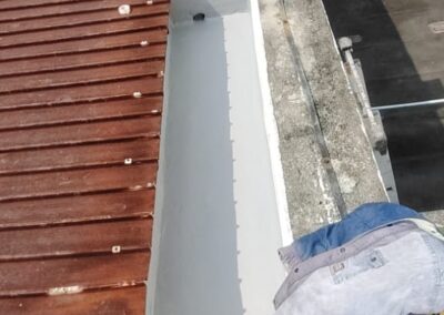 Concrete gutter channel showing finished grey coating alongside an adjacent untreated, moss-stained section in the same frame