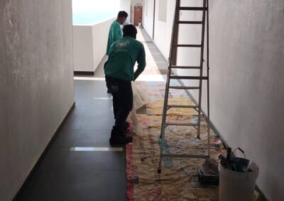 Vseal technicians on-site in a condominium corridor with a ceiling access point opened for slab leak inspection