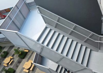 Top-down view of a freshly refurbished exterior metal staircase overlooking a school courtyard